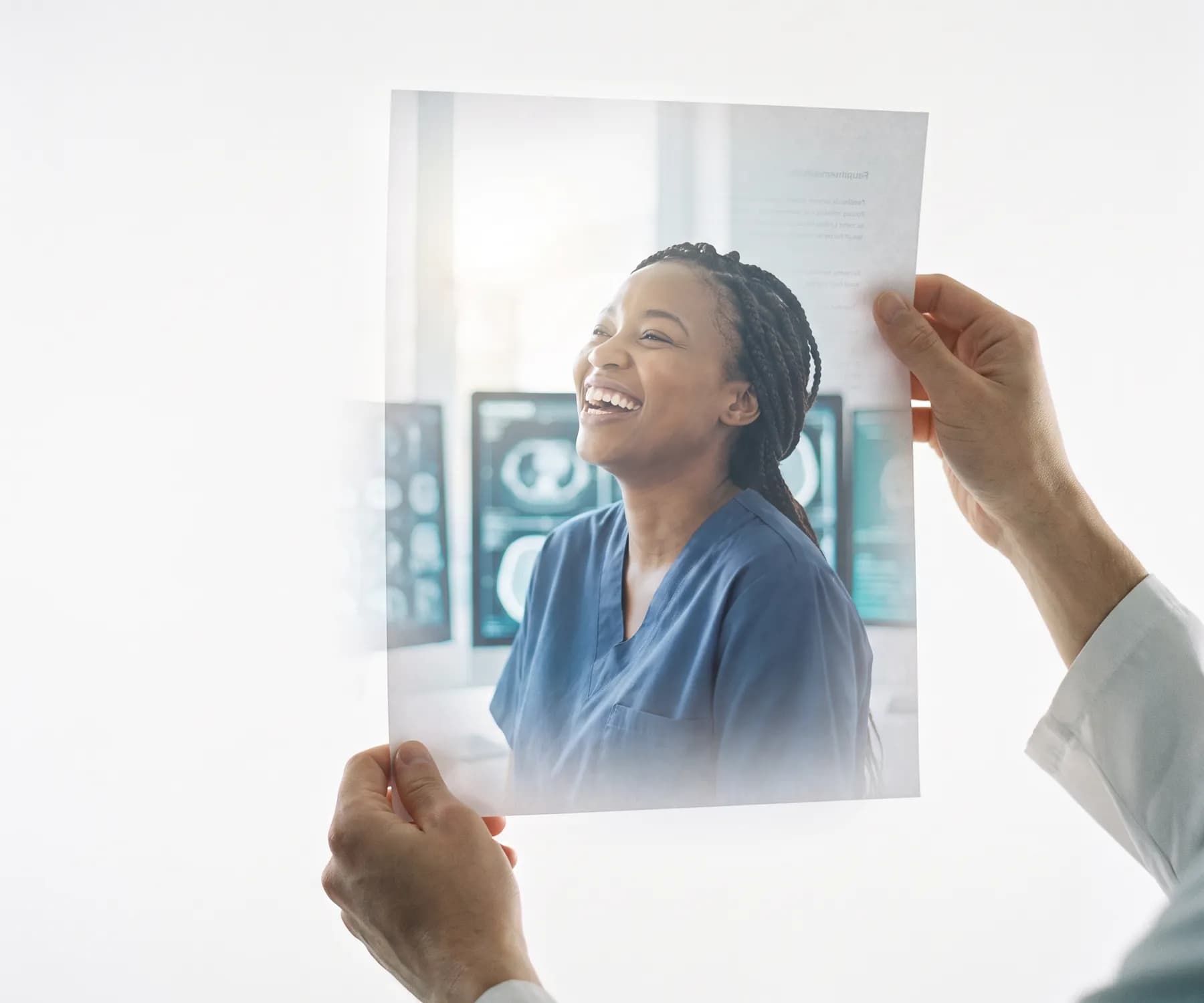 A hand holding up a printed profile of a smiling clinician toward the light